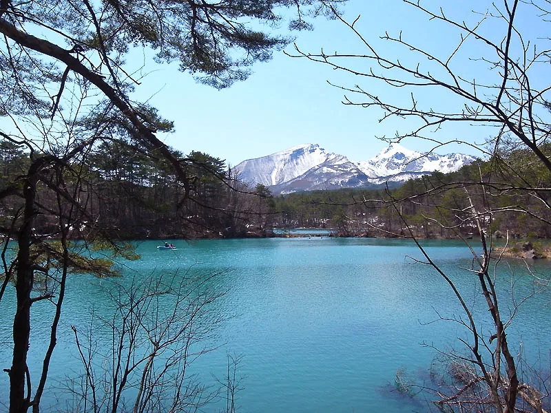 Blue-green water and forest at Goshikinuma Ponds in Urabandai, Kitashiobara