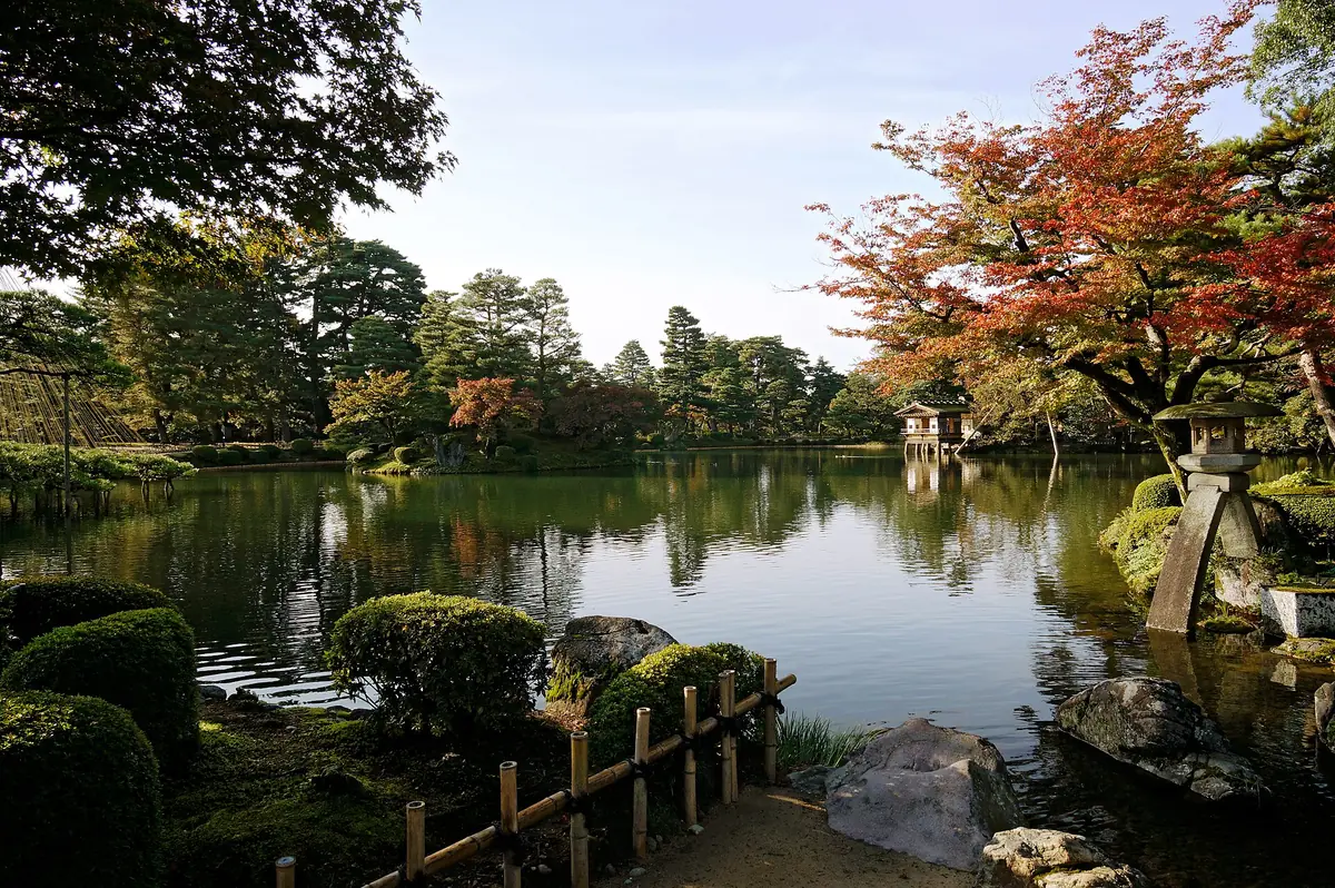 Pond, stone lanterns and autumn trees in Kenrokuen Garden, Kanazawa