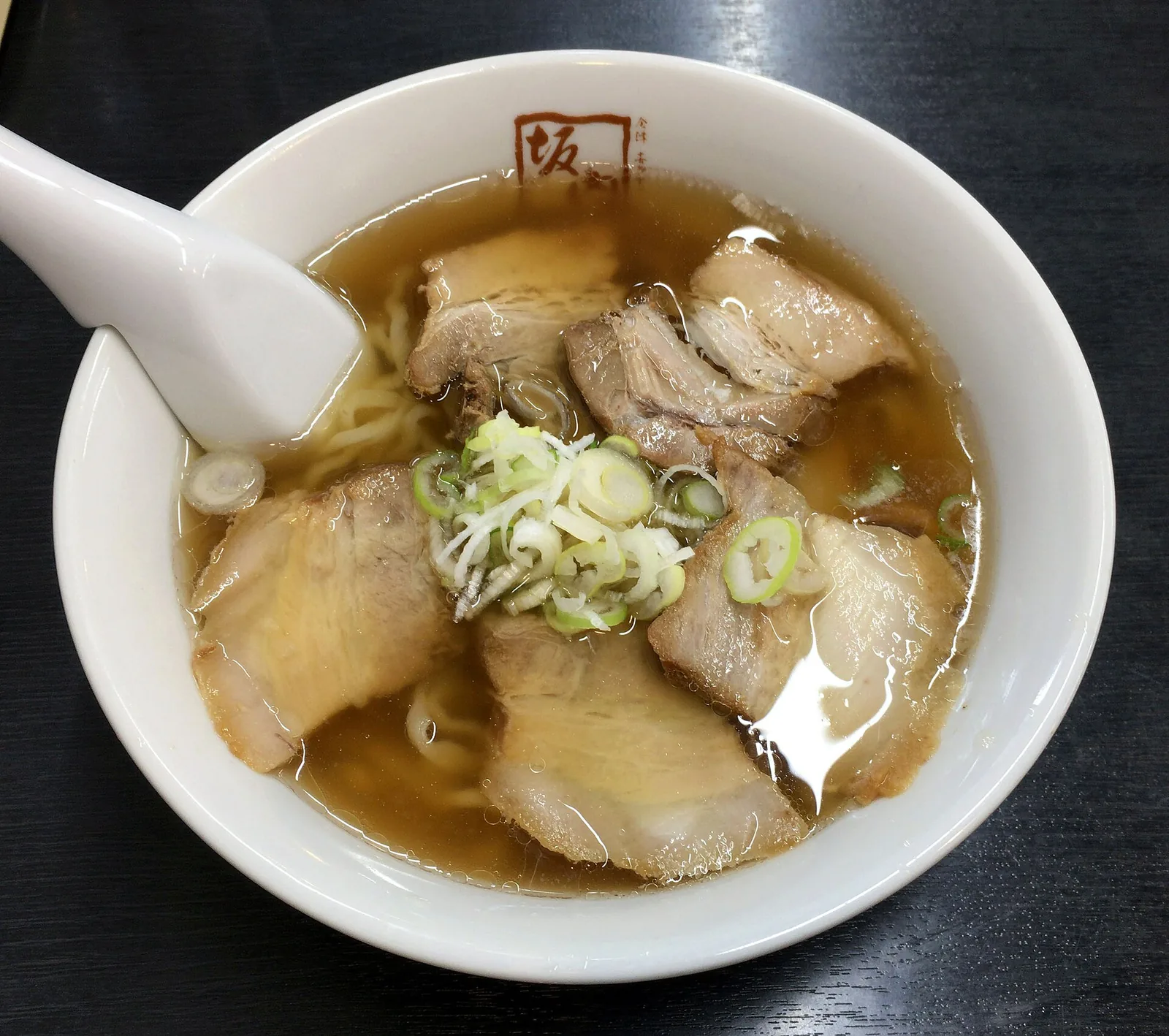 A bowl of Kitakata ramen with wavy noodles, sliced pork and bamboo shoots