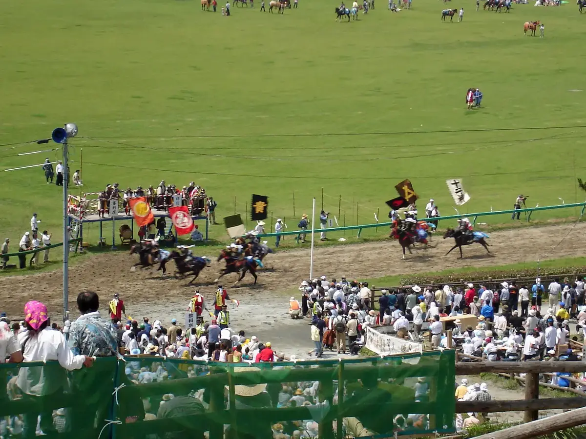 Armored riders racing with banners during Soma Nomaoi in Minamisoma